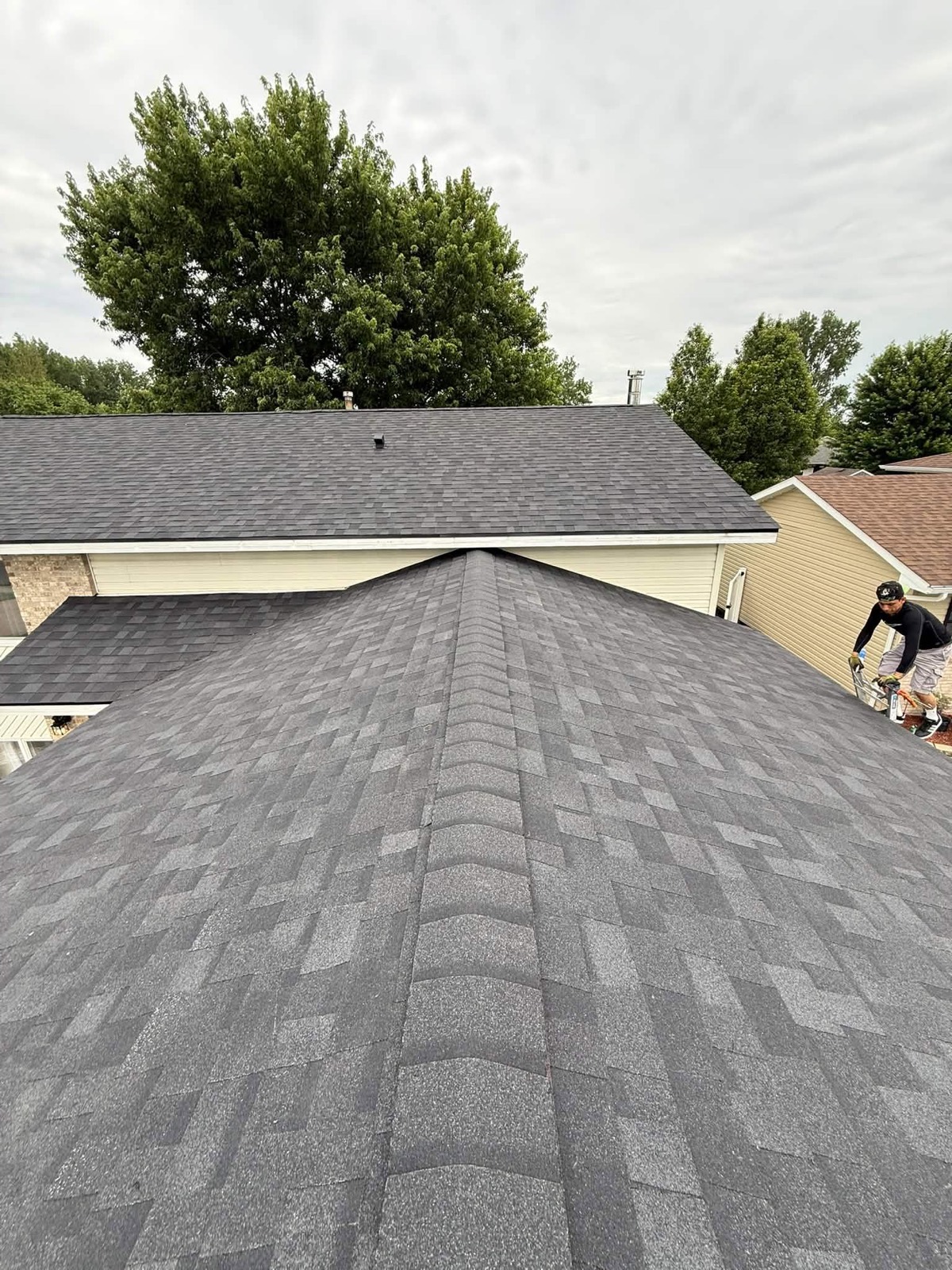 Crew finishing a new charcoal shingle roof