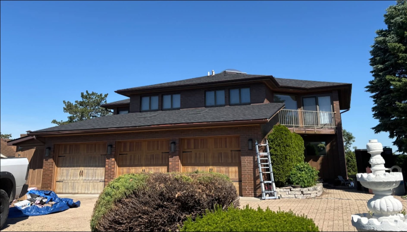 Finished charcoal architectural shingle roof on a brick two-story home